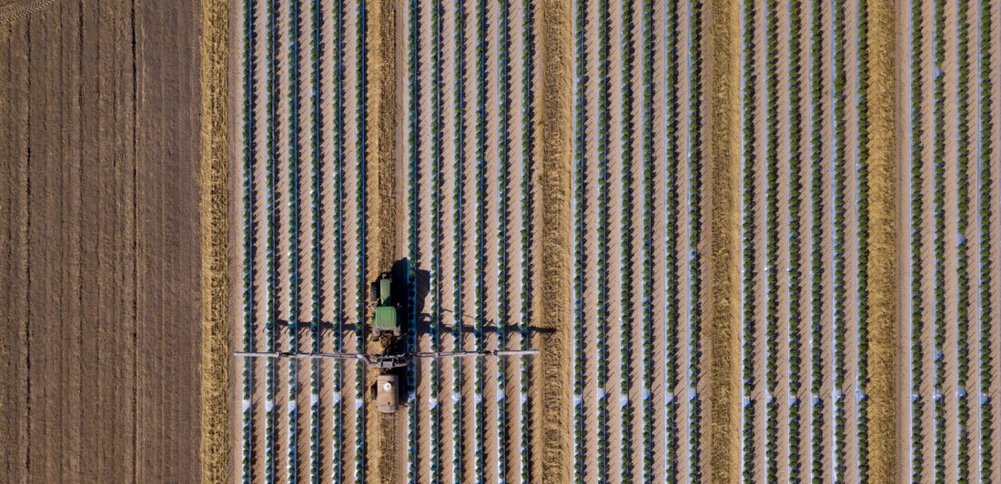 Overhead image of tractor treating crops for pests