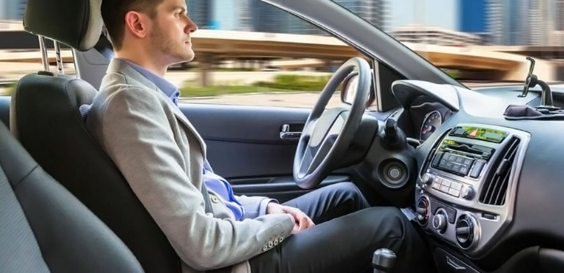 Image of man sitting in a self driving vehicle