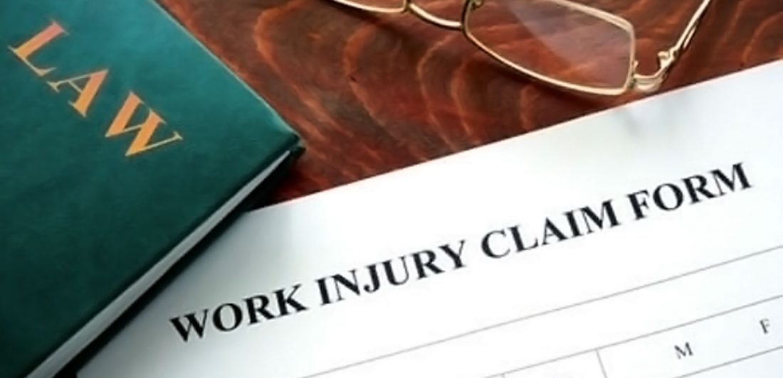 Image of work injury claim form, glasses, and law book