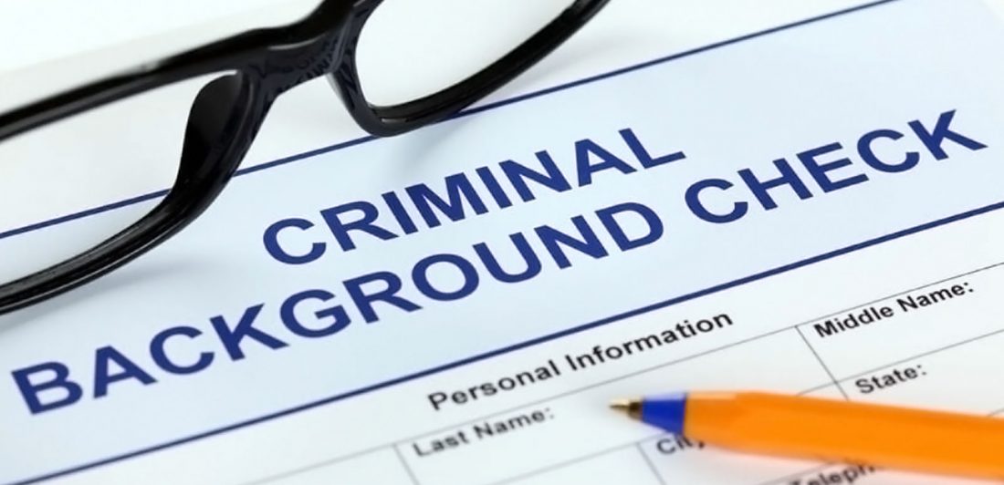 Image of criminal background check form, pen, and eyeglasses