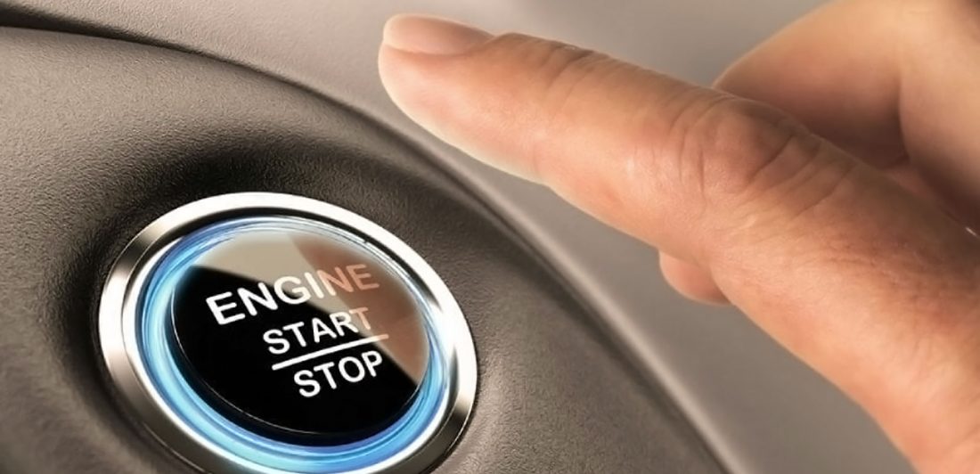 Image of hand pushing engine start stop button