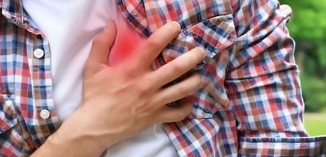 Image of man with his hand over his heart in apparent pain