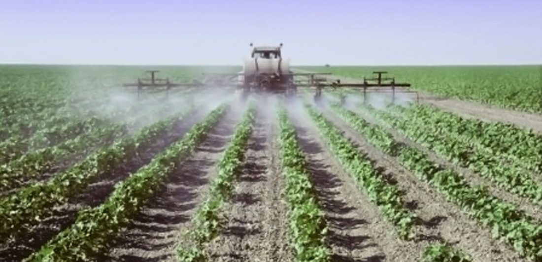 Image of tractor treating crops for pests