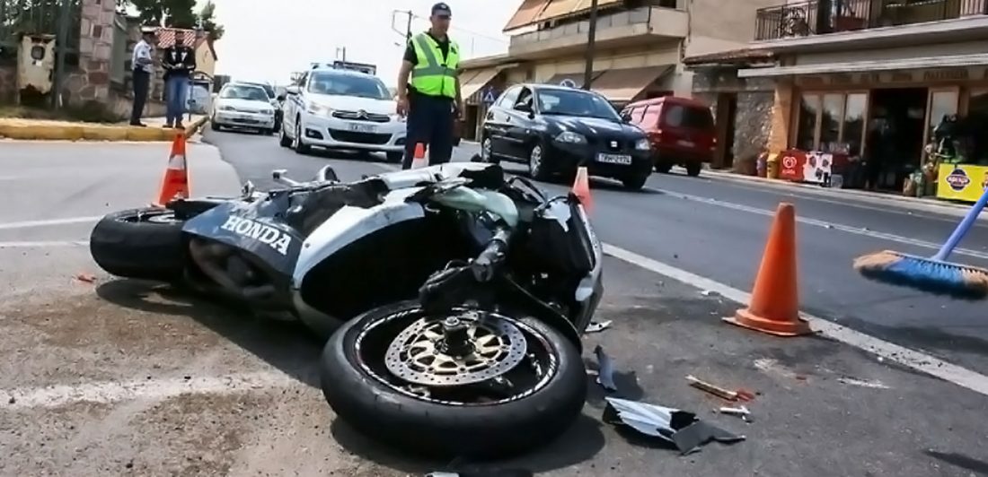 Image of motorcycle accident on a busy city street with public safety workers standing by