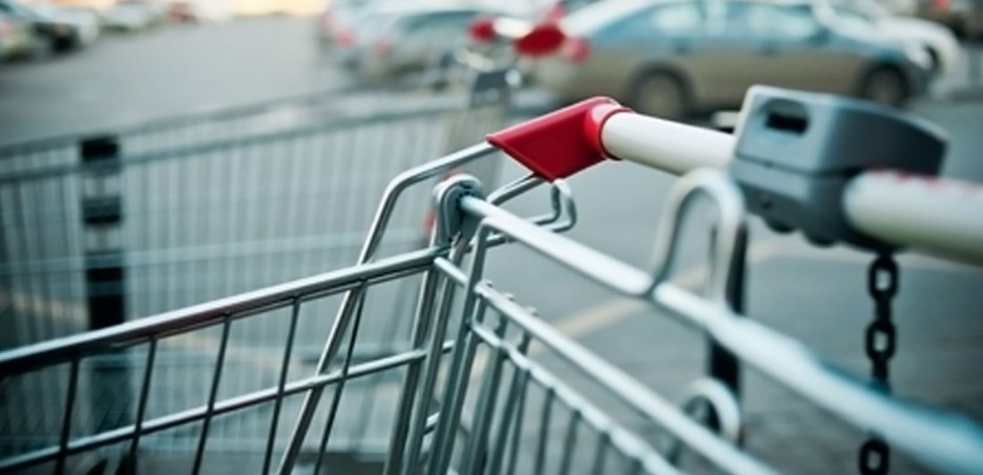 Image of shopping cart in a parking lot full of cars