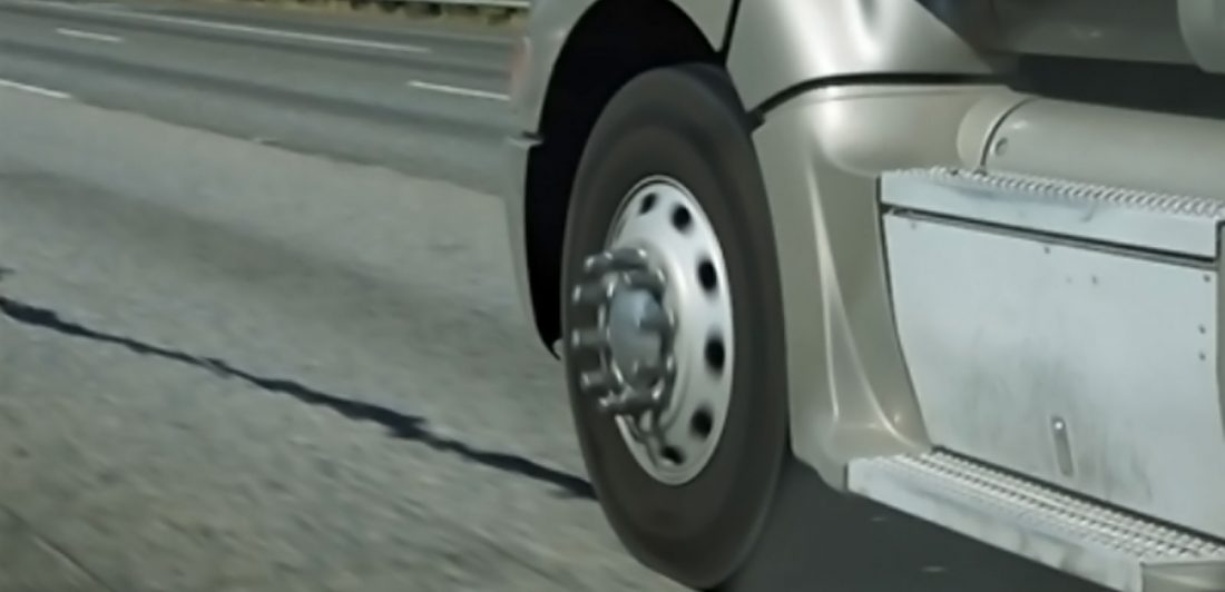 Close up image of semi truck tire and wheel well