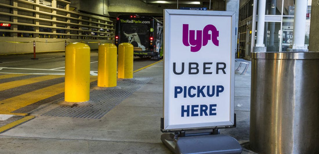 Lyft and Uber sign outside of an airport at pickup area