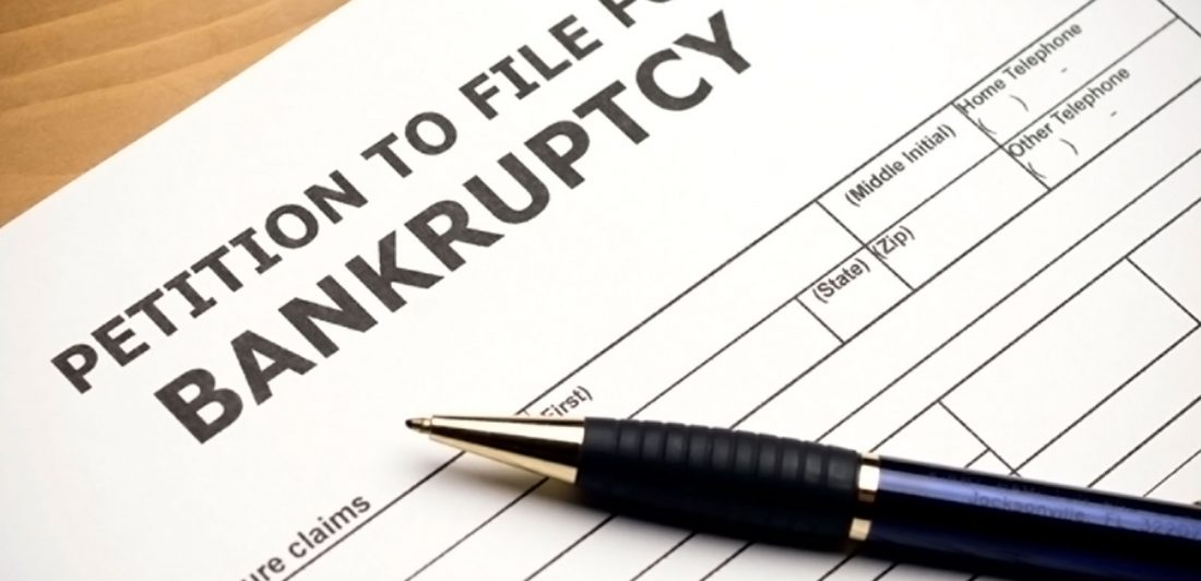 Image of petition to file for bankruptcy document with a blue pen