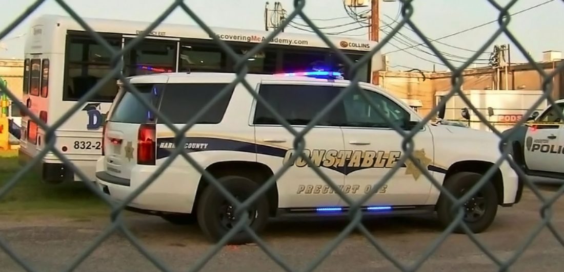 Image of police vehicles behind a chain link fence