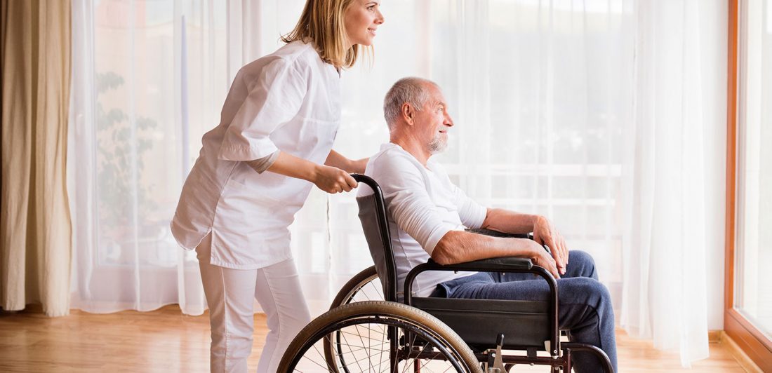 Image of woman pushing an elderly man in a wheel chair