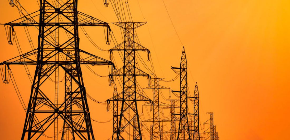 Image of high voltage powerlines with an orange sky