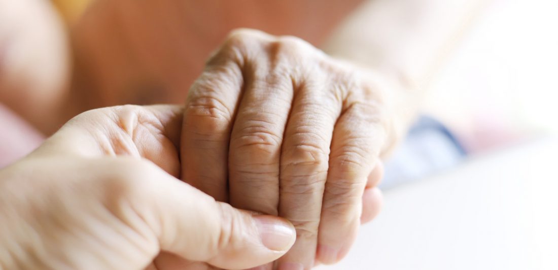 Image of elderly person holding hands with someone