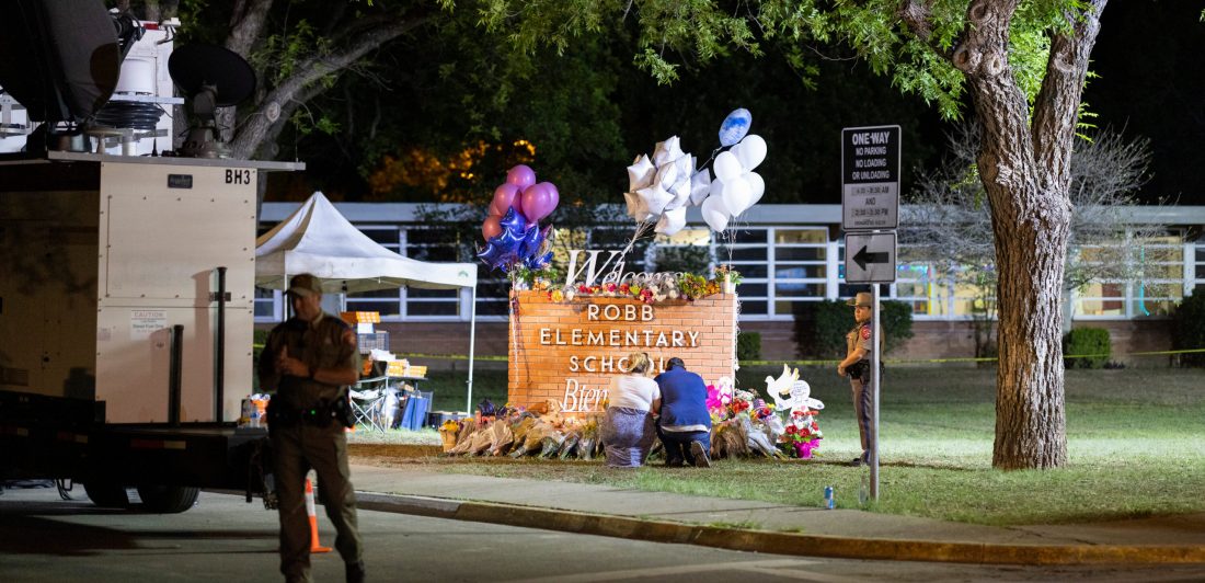 Image of memorial set up at Robb Elementary School sign