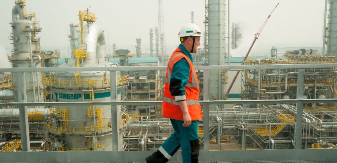 Image of man in safety gear walking at a chemical plant